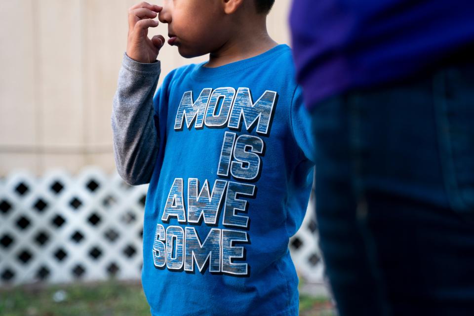 Juliana's son stands with her outside their home in Immokalee. Juliana is an undocumented farmworker, and her family has struggled financially during the pandemic because of limited work and family members contracting COVID-19.