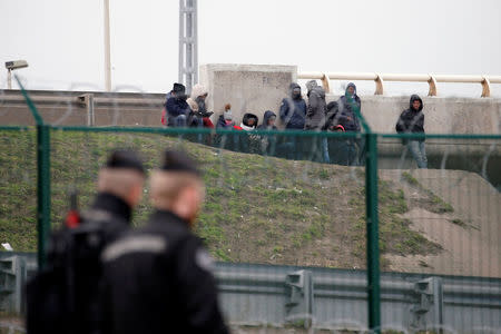 Migrants gather near an bridge as French gendarmes patrol the day after a brawl between Erithean and Afghan migrants that left four in critical condition in Calais, France, February 2, 2018. REUTERS/Pascal Rossignol