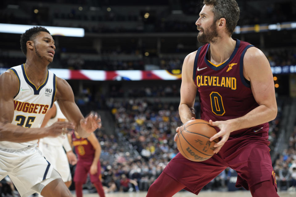 Cleveland Cavaliers forward Kevin Love, right, looks to shoot a basket over Denver Nuggets guard P.J. Dozier in the first half of an NBA basketball game Monday, Oct. 25, 2021, in Denver. (AP Photo/David Zalubowski)