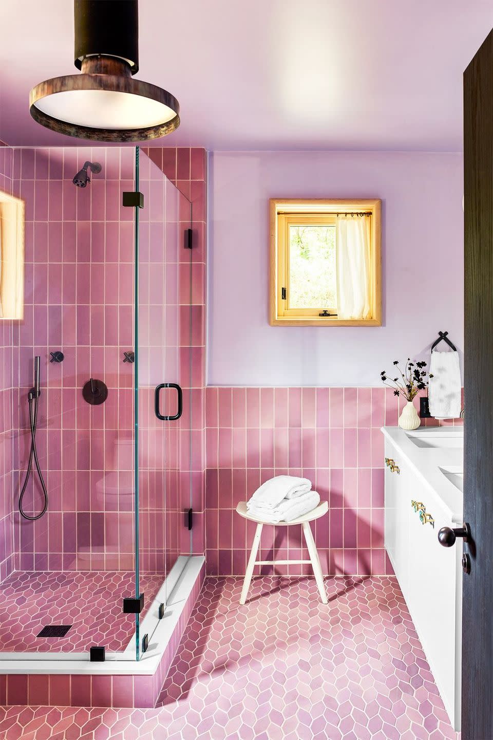 <p>This bathroom by designer Kureck Jones is a lesson in how to have fun with tile and color. The pink subway tiles on the wall and the diamond, almost leaf-like motif on the floors of this bathroom bring in a surge of energy while the lavender paint sets an instant calm. The brass industrial-style fixtures and lighting add just enough contrast and intrigue to the otherwise sweet and romantic space. </p>