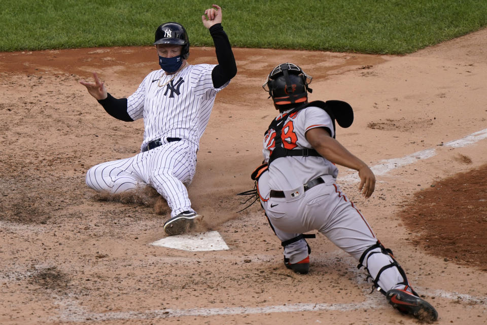 New York Yankees Clint Frazier, left, is safe scoring ahead of the tag by Baltimore Orioles catcher Pedro Severino (28) on pinch-hitter Gleyber Torres's two-run double during the eighth inning of a baseball game, Sunday, Sept. 13, 2020, at Yankee Stadium in New York. (AP Photo/Kathy Willens)