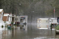 Standing floodwater from the Pearl River still surrounds a number of mobile homes in the back portion of the Harbor Pines community in Ridgeland, Miss., Tuesday, Feb. 18, 2020. Some residents are allowed temporary permission to enter their homes in the non-flooded portion of the mobile home community to retrieve clothing and prescriptions. (AP Photo/Rogelio V. Solis)