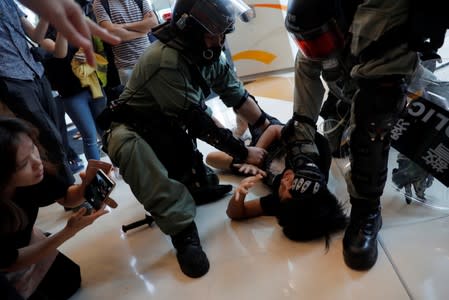 Riot police officers detain an anti-government protester in Tsuen Wan, near the site where police shot a protester with live ammunition on China's National Day in Hong Kong