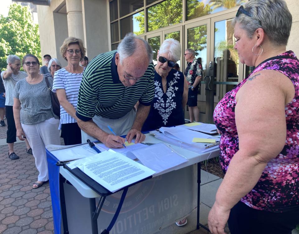 Retired Shasta County Superintendent of schools Charlie Menoher signs the petition to recall Supervisor Kevin Crye before the Tuesday, May 16, 2023, Board of Supervisors meeting.