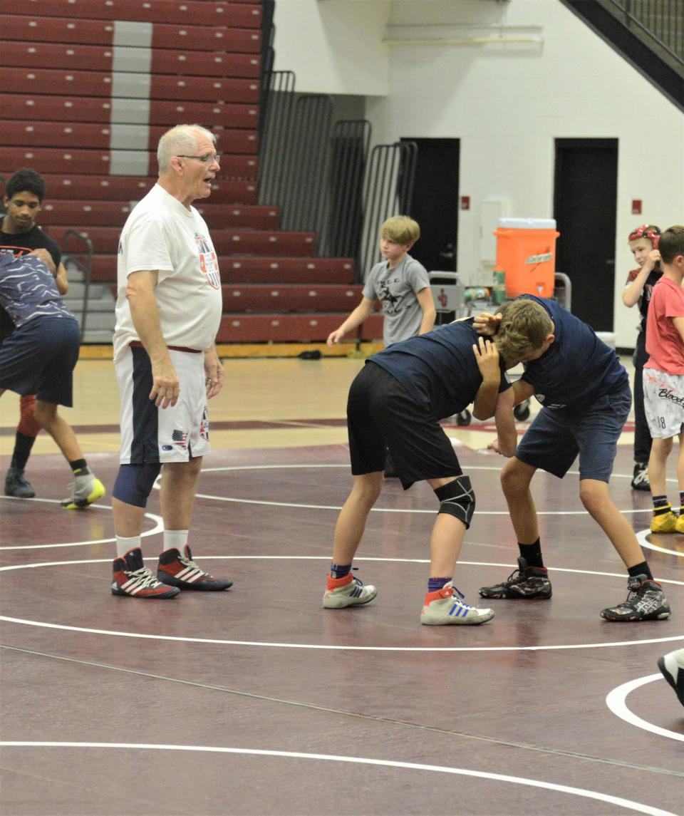 Long-time wrestling instructor Rob Waller (white) works with wrestlers during his Rob Waller All-American Camp, which was held on Wednesday and Thursday at John Glenn.