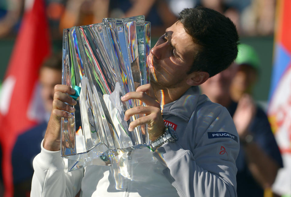 Novak Djokovic, of Serbia, kisses the trophy after he beat Roger Federer, of Switzerland, 3-6, 6-3, 7-6 to win the final match of the BNP Paribas Open tennis tournament, Sunday, March 16, 2014, in Indian Wells, Calif. (AP Photo/Mark J. Terrill)