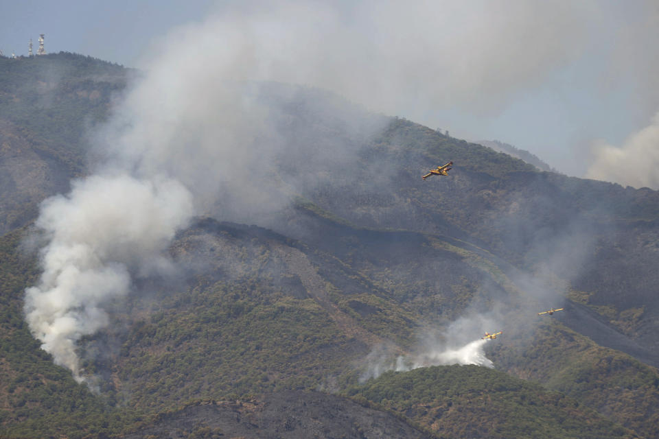 Hydroplanes operate on a wildfire in Estepona, in Malaga province, Spain, Saturday, Sept. 11, 2021. Soldiers were deployed in southeastern Spain Sunday to join the battle against a major wildfire that is burning for a fourth day, invigorated by a stray ember that has sparked a new hotspot. (Álex Zea/Europa Press via AP)
