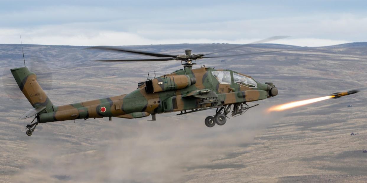 A Japanese AH-64D Apache helicopter firing a Hellfire missile