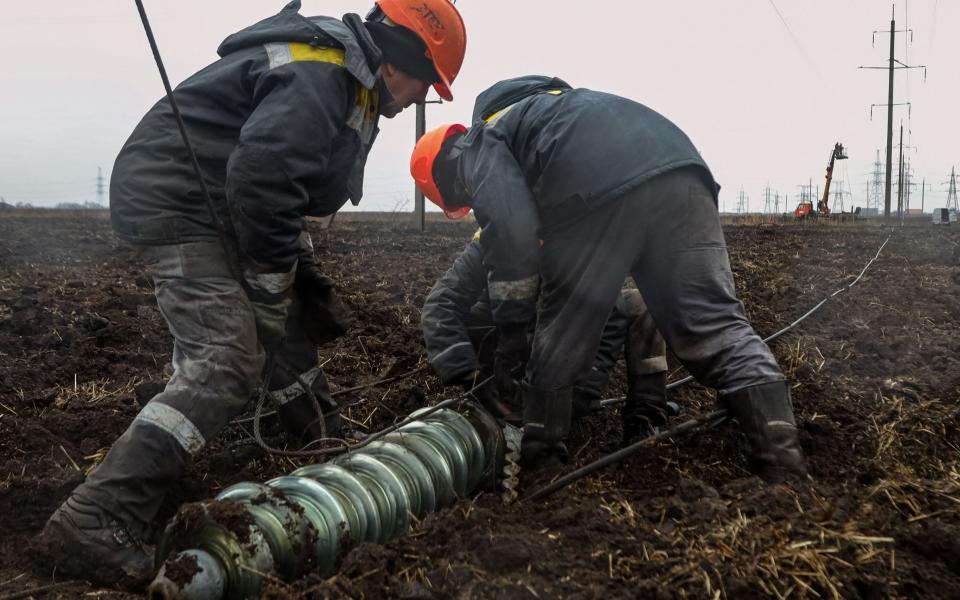 Workers repair high-voltage power lines cut by recent missile strikes near Odessa - OLEKSANDR GIMANOV/AFP via Getty Images