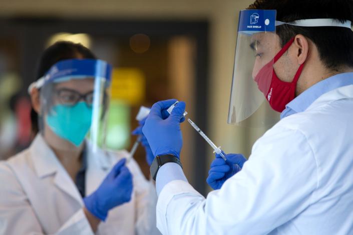 Pharmacists prepare doses of the COVID-19 vaccine at the Life Care Center of Kirkland on Dec. 28, 2020 in Kirkland, Wash. The Life Care Center of Kirkland, a nursing home, was an early epicenter for coronavirus outbreaks in the U.S.