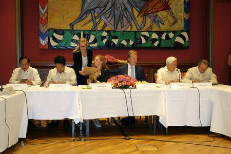 Philippines government negotiators Jesus Dureza (L to R), Silvestre Bello, Norwegian peace talks facilitator Elisabeth Slattum, Norwegian Foreign Minister Boerge Brende, communist leaders Luis Jalandoni and Jose Maria Sison sign an indefinite ceasefire agreement at a meeting in Oslo, Norway, August 26, 2016. REUTERS/Alister Doyle