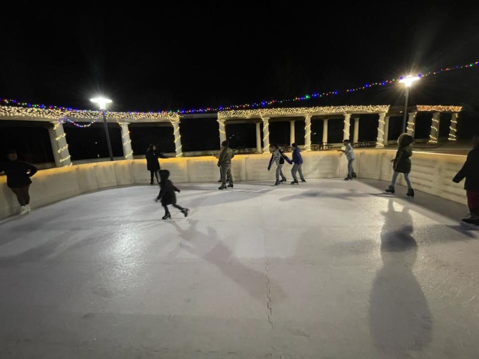 Guests ice skate on the temporary rink set up over the splash pad at Riverfront Park in Montgomery.