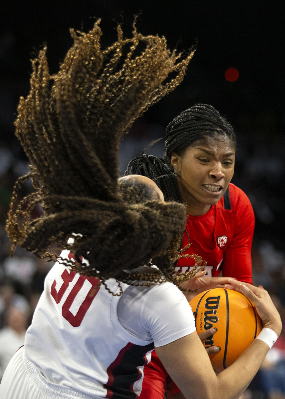 Utah forward Dasia Young (34) and Stanford guard Haley Jones (30) fight for control of the ball during the first half of an NCAA college basketball game for the Pac-12 tournament championship Sunday, March 6, 2022, in Las Vegas. (AP Photo/Ellen Schmidt)