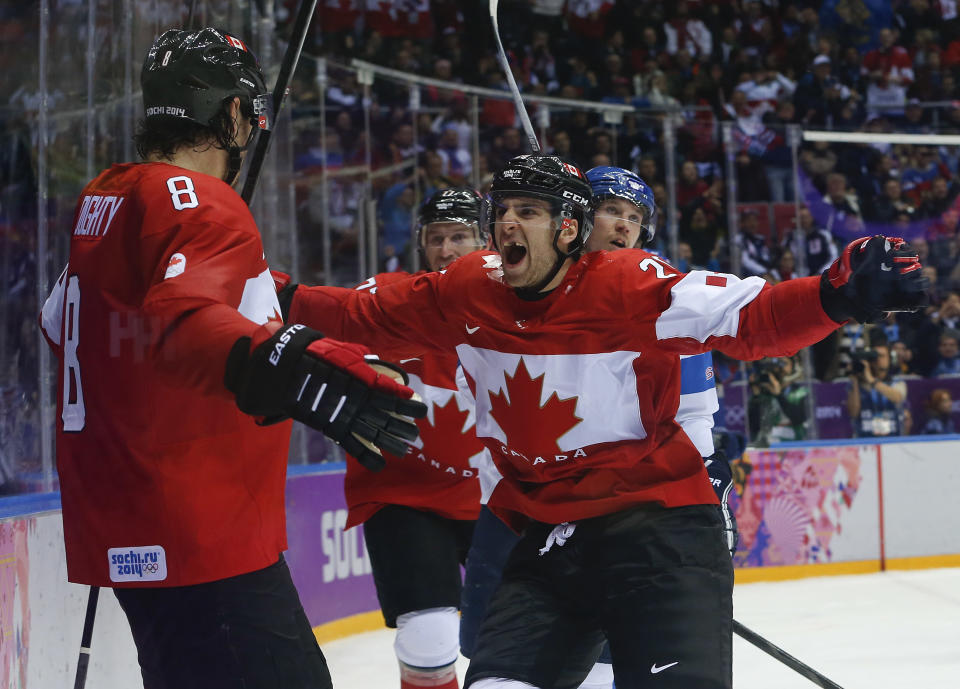 Canada forward John Tavares, right, and forward Jeff Carter, second from left, celebrate with defenseman Drew Doughty (8) after Doughty scored a sudden death overtime goal against Finland during a men's ice hockey game at the 2014 Winter Olympics, Sunday, Feb. 16, 2014, in Sochi, Russia. Canada won 2-1. (AP Photo/Mark Humphrey)