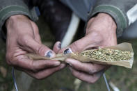 Un hombre hace un cigarrillo de marihuana en un parque de Toronto el miércoles 17 de octubre de 2018. (Chris Young/The Canadian Press via AP)