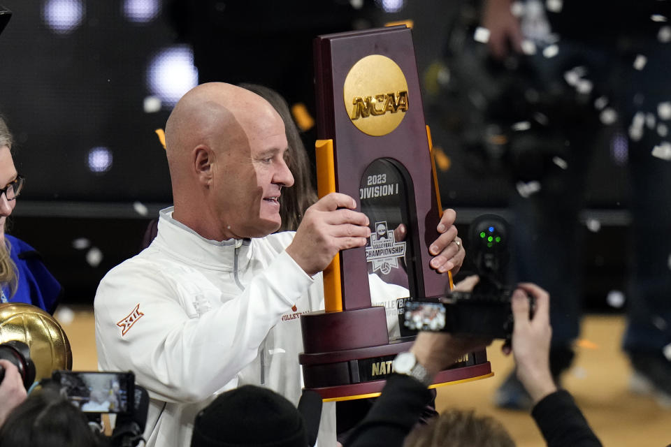 Texas head coach Jerritt Elliott holds up the trophy after the team defeated Nebraska during the championship match in the NCAA Division I women's college volleyball tournament Sunday, Dec. 17, 2023, in Tampa, Fla. (AP Photo/Chris O'Meara)