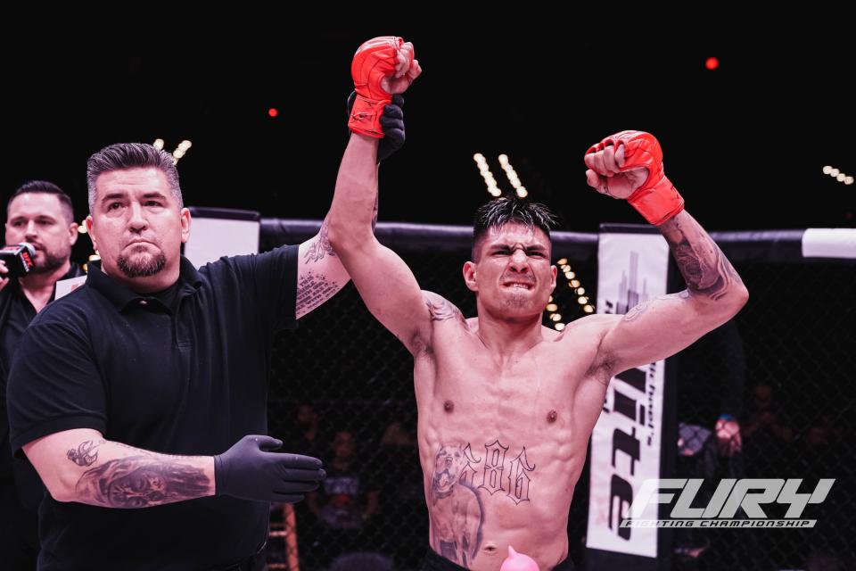 Referee Frank Collazo (left) raises the hand of Fury FC 76 main event winner Edgar Chairez (right).