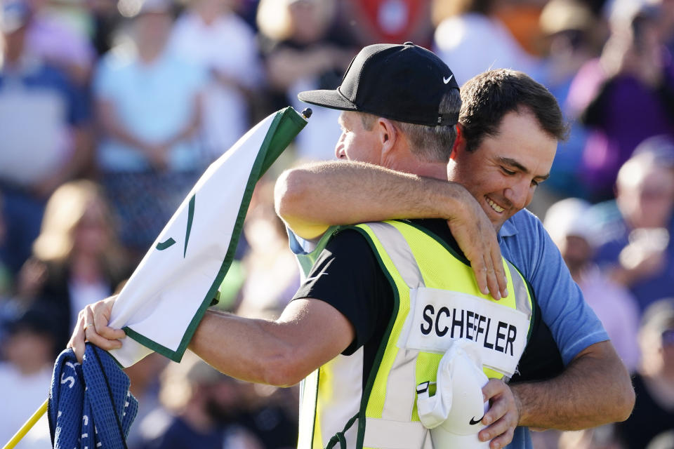 Scottie Scheffler, right, hugs his caddie Ted Scott after winning the Phoenix Open golf tournament, Sunday, Feb. 12, 2023, in Scottsdale, Ariz. (AP Photo/Darryl Webb)