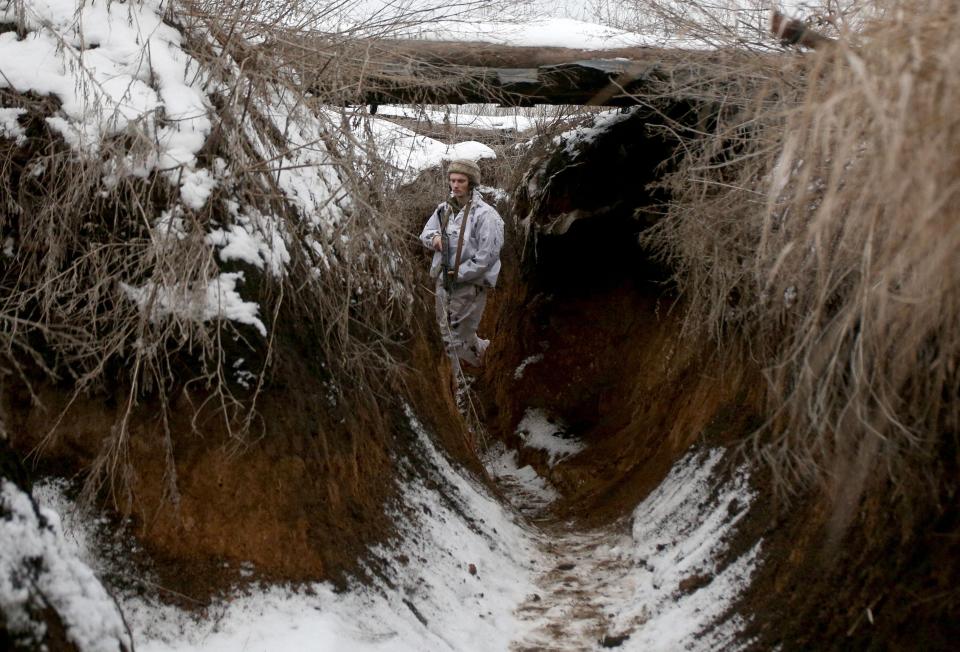 A Ukrainian soldier walks along a snow covered trench on the front line with the Russia-backed separatists near Verkhnetoretskoye village, in the Donetsk region.