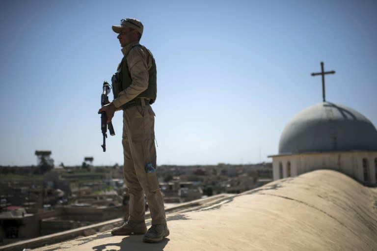 A militiaman stands guard during Easter mass at the Mar Yohanna church in Iraq's predominantly Christian town of Qaraqosh on April 16, 2017