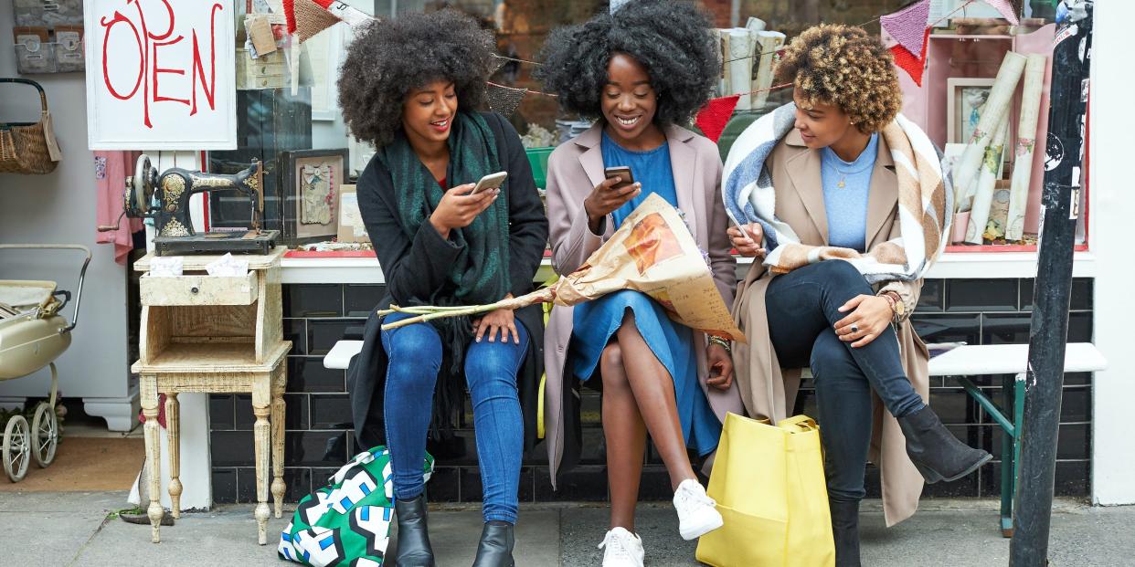 friends using holding smart cell phone outside shop