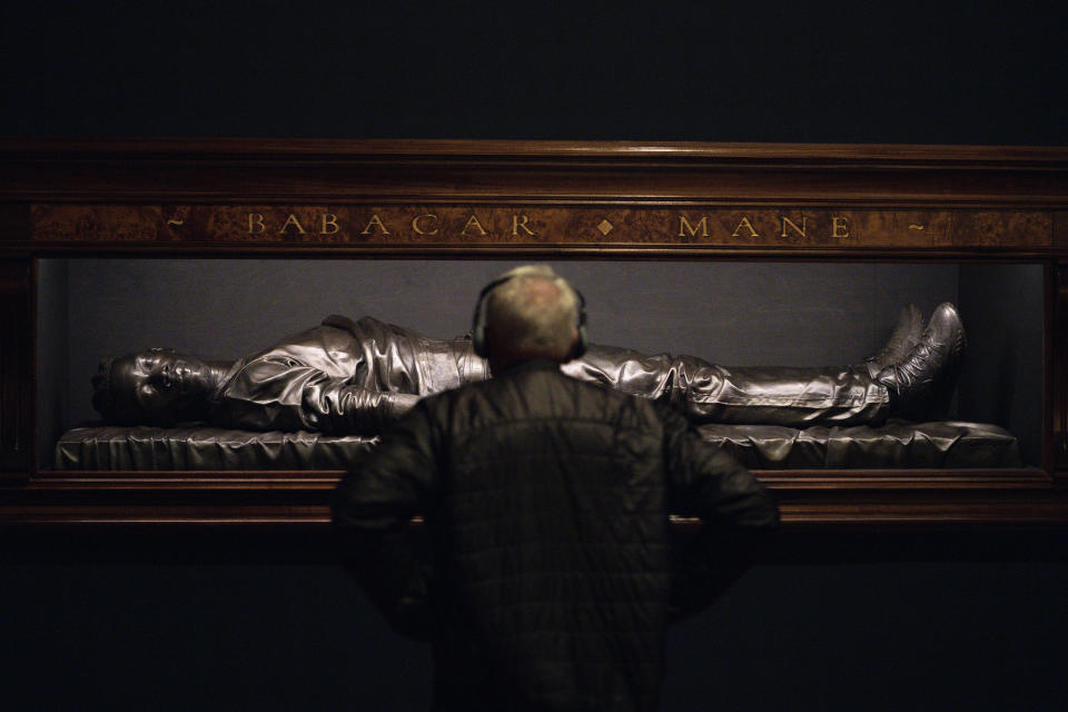 A man looks at a bronze sculpture by Kehinde Wiley titled "The Body of the Dead Christ in the Tomb," at the de Young Museum in San Francisco, Friday, March 24, 2023. The sculpture is part of the "Kehinde Wiley: An Archaeology of Silence," exhibition. (AP Photo/Godofredo A. Vásquez)