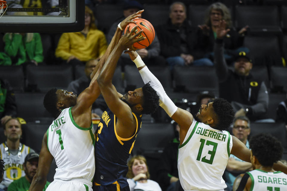 California forward ND Okafor, second from left, has his shot blocked by Oregon center N'Faly Dante (1) as forward Quincy Guerrier (13) comes on the play during the first half of an NCAA college basketball game Thursday, March 2, 2023, in Eugene, Ore. (AP Photo/Andy Nelson)