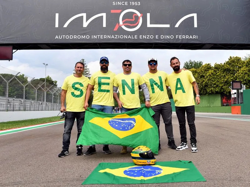 Seguidores del piloto brasileño de Fórmula Uno Ayrton Senna posan en la pista en el aniversario 30 de su muerte