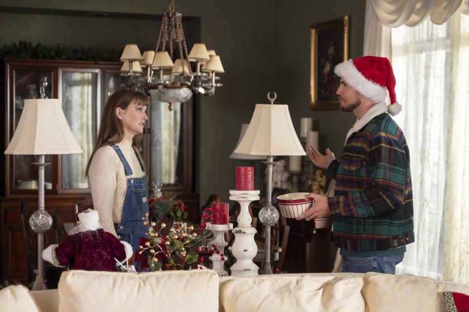 leighton meester and robbie amell star in exmas, a young couple stand in a living room at christmas arguing