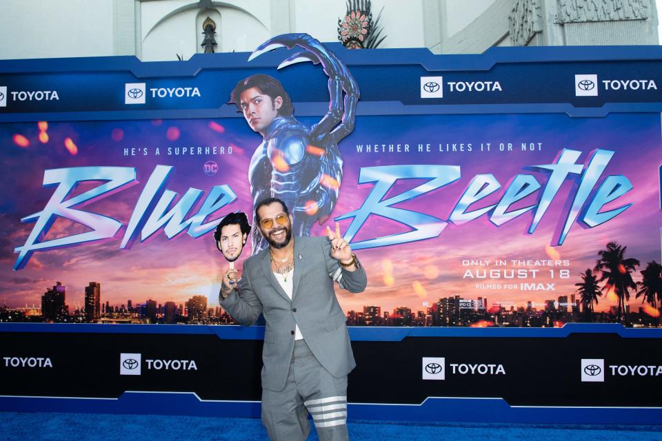 Amid the ongoing writers and actors strike, "Blue Beetle" director Àngel Manuel Soto holds a picture of star Xolo Maridueña at the premiere of the superhero movie on Tuesdat at the TCL Chinese Theatre in Los Angeles.