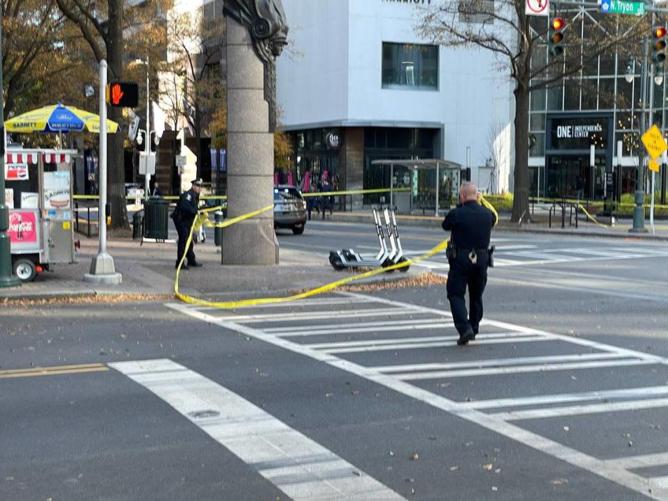 Charlotte-Mecklenburg police officers clear the scene of a shooting at Trade and Tryon streets in uptown Charlotte, NC, on Tuesday, Dec. 7, 2021. A suspect was arrested after a foot chase, police said.