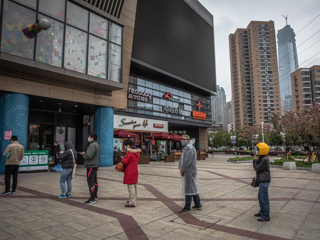 Shoppers queuing a few feet apart in China: EPA