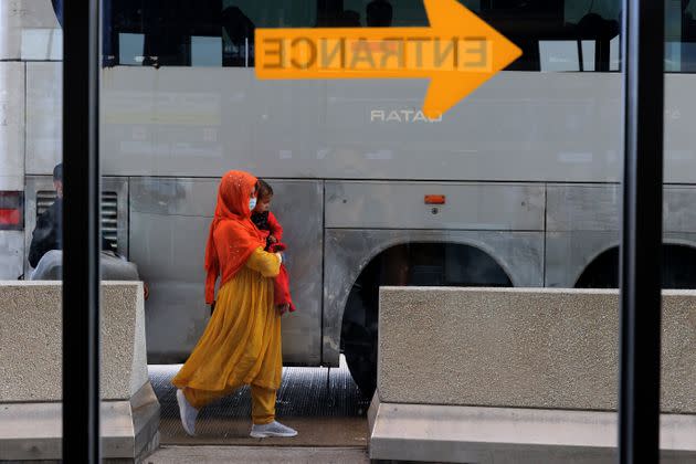 Refugees board buses that will take them to a processing center after they arrive at Dulles International Airport after being evacuated from Kabul following the Taliban takeover of Afghanistan Aug. 27, 2021, in Dulles, Virginia.