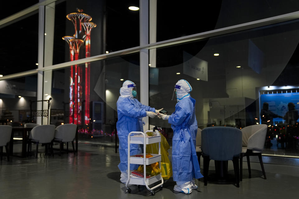 FILE - Two workers scan a tube after collecting swab samples from tables and chairs for COVID-19 testing at the main media center of the 2022 Winter Olympics, Feb. 10, 2022, in Beijing. The possibility of a large outbreak in the bubble, potentially sidelining athletes from competitions, has been a greater fear than any leakage into the rest of China. (AP Photo/Jae C. Hong, File)