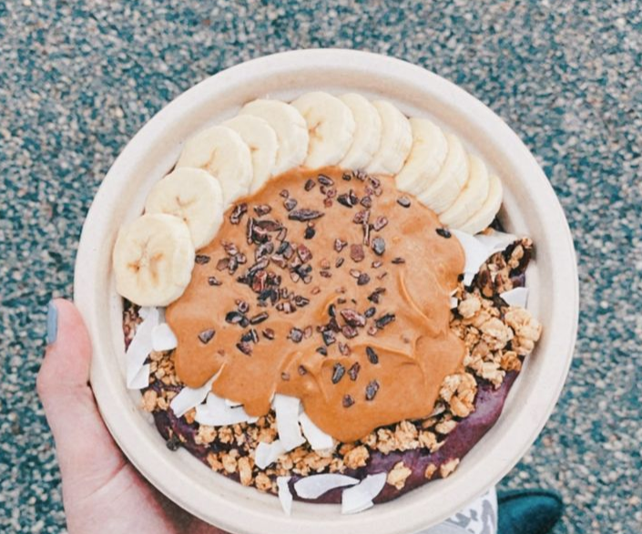 The Acai Bowl (blended acai/ guarana, banana and almond milk topped with fresh banana, peanut butter, granola, coconut, cacao nibs) is on the menu at The Juicery.