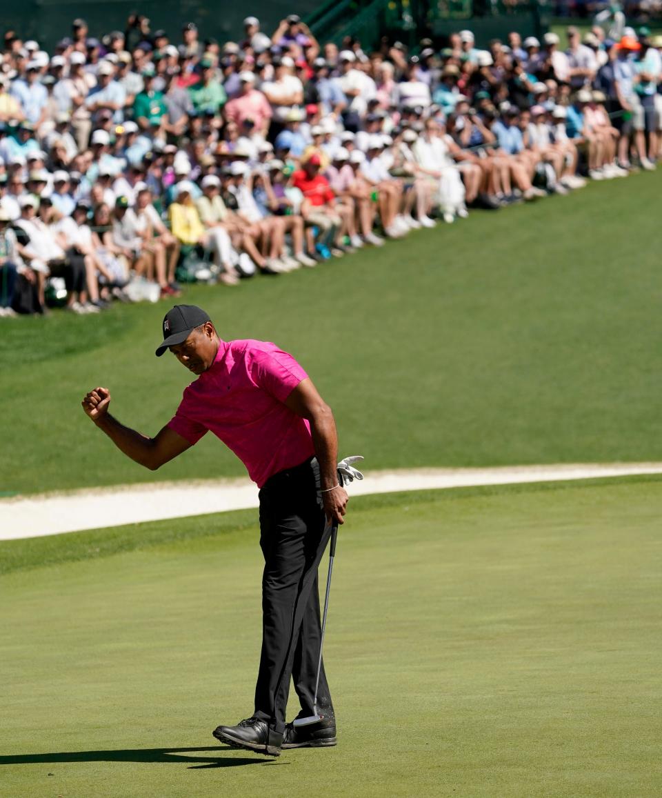Tiger Woods pumps his fist after sinking a putt for a birdie on the 16th hole during the first round of the Masters.