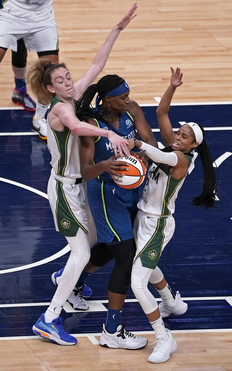 Minnesota Lynx center Sylvia Fowles (34), center, is double-teamed by Seattle Storm forward Breanna Stewart, left, and guard Jordin Canada (21) during the third quarter of a WNBA basketball game Thursday, May 20, 2021, in Minneapolis. (Leila Navidi/Star Tribune via AP)