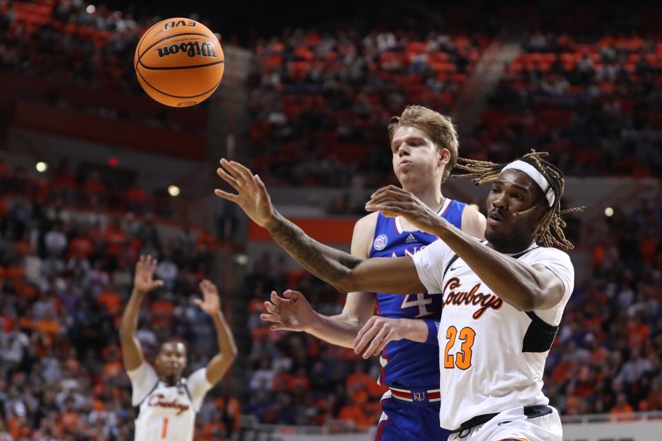 Oklahoma State forward Tyreek Smith (23) and Kansas guard Gradey Dick (4) reach for the ball during a game Tuesday at Gallagher-Iba Arena in Stillwater, Oklahoma.