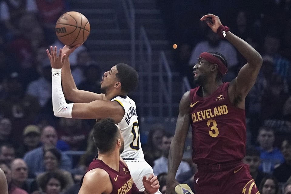 Indiana Pacers guard Tyrese Haliburton (0) goes to the basket between Cleveland Cavaliers guards Max Strus, left, and Caris LeVert (3) during the first half of an NBA basketball game Saturday, Oct. 28, 2023, in Cleveland. (AP Photo/Sue Ogrocki)