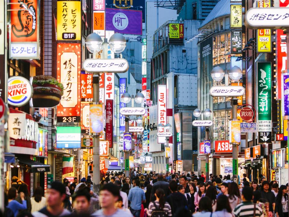 A busy street of people, signs, and lights, in Tokyo.