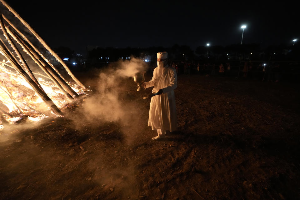 An Iranian Zoroastrian priest walks near a giant bonfire in a ceremony celebrating Zoroastrians ancient mid-winter Sadeh festival the outskirts of Tehran, Iran, Tuesday, Jan. 30, 2024. Hundreds of Zoroastrian minorities gathered after sunset to mark their ancient feast, creation of fire, dating back to Iran's pre-Islamic past. (AP Photo/Vahid Salemi)