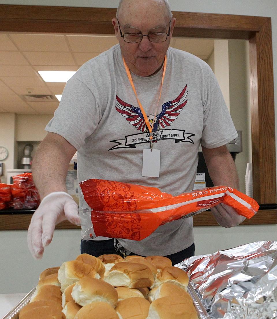 Volunteer Danny Baker puts out dinner rolls before the start of the annual Berth's Mission Free Community Easter Meal Saturday.