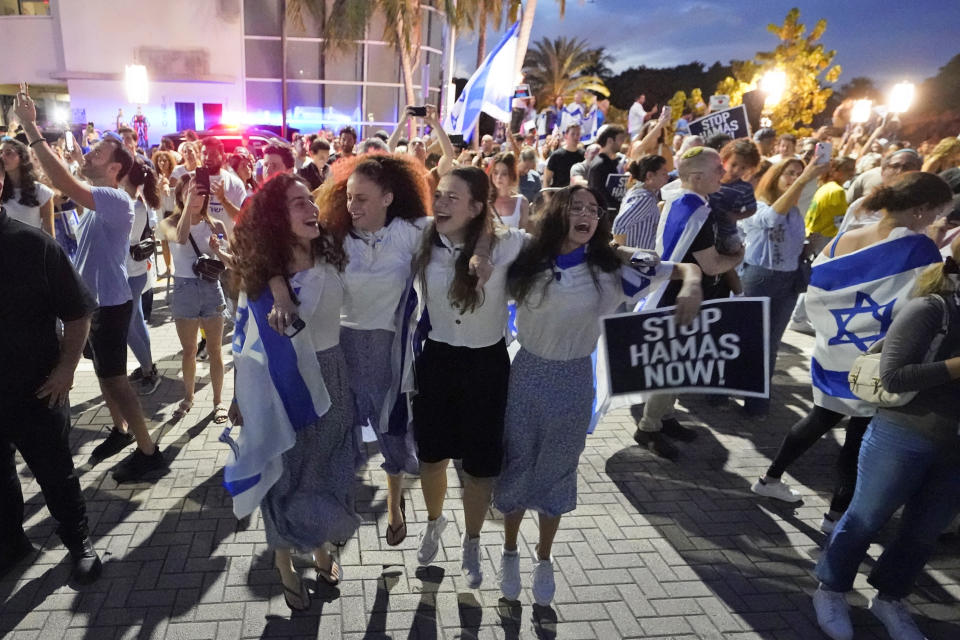 FILE - A group of Israeli girls jump and sing as they attend a rally in support of Israel, at the Holocaust Memorial Miami Beach, Oct. 10, 2023, in Miami Beach, Fla. An estimated 525,000 Jews live in Miami's metropolitan area according to the American Jewish Population Project at Brandeis University. In South Florida, rabbis and community leaders are pushing their congregations to call their lawmakers and insist they back Israel as it ramps up its offensive. (AP Photo/Wilfredo Lee, File)