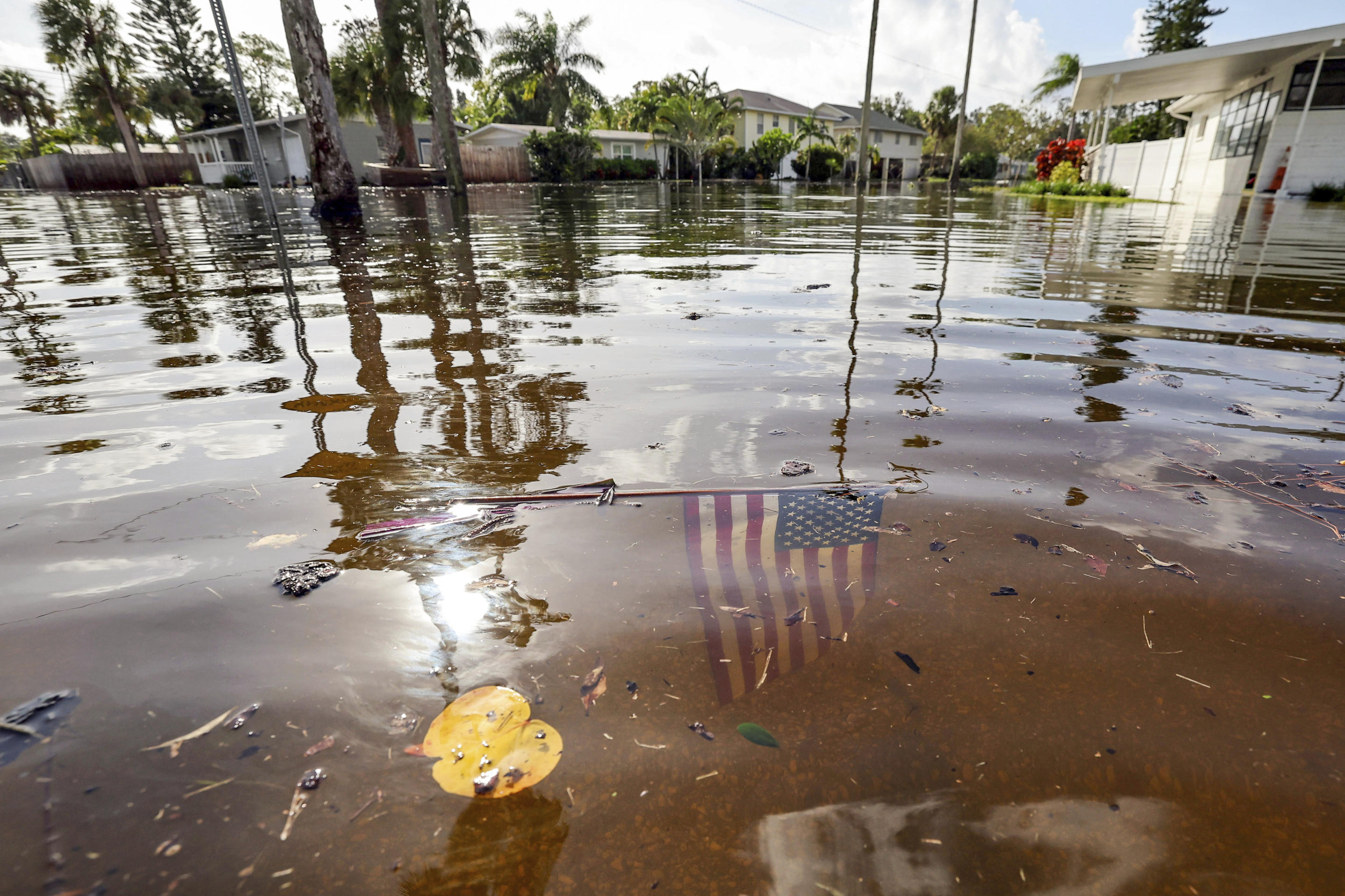 An American flag lies submerged in flood waters following Hurricane Helene in the Shore Acres neighborhood on Friday, Sept. 27, 2024, in St. Petersburg, Fla. (Mike Carlson/AP)