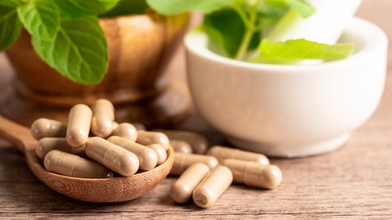 Capsules next to mortar and pestle