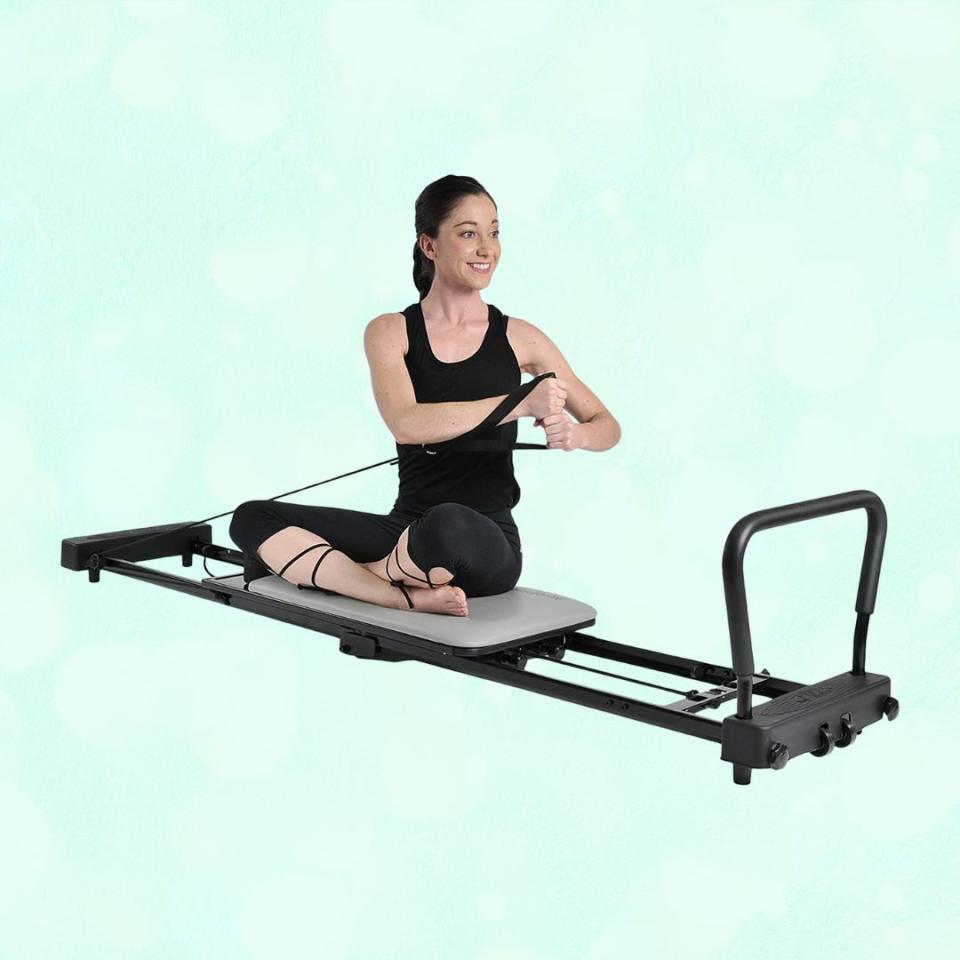 If you just have to get a reformer but don't want to shell out thousands of dollars, this budget- and beginner-friendly option is for you. It has three-cord elastic resistance, a padded foot bar, and a textured, padded platform for comfort. It's also super portable as it has wheels for easy transport and a folding frame for storage. It measures 85.25 inches long and 17.5 inches wide when in use.Promising review: 