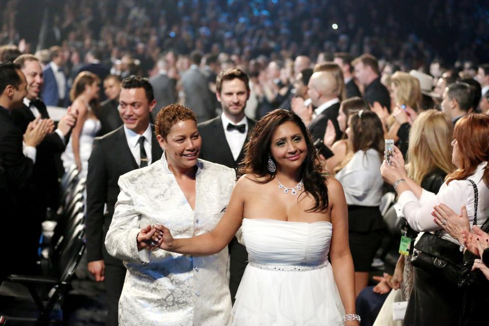 ADDITIONAL WEDDING DETAILS INCLUDED - Audience members participate in a same sex wedding during a performance of "Same Love" by Macklemore and Ryan Lewis at the 56th annual Grammy Awards at Staples Center on Sunday, Jan. 26, 2014, in Los Angeles. With Queen Latifah presiding from the stage and the music playing, 33 straight and gay couples lined the aisle dressed in wedding finery. Under Latifah's command, they exchanged rings near the end of Sunday night's show televised on CBS. (Photo by Matt Sayles/Invision/AP)