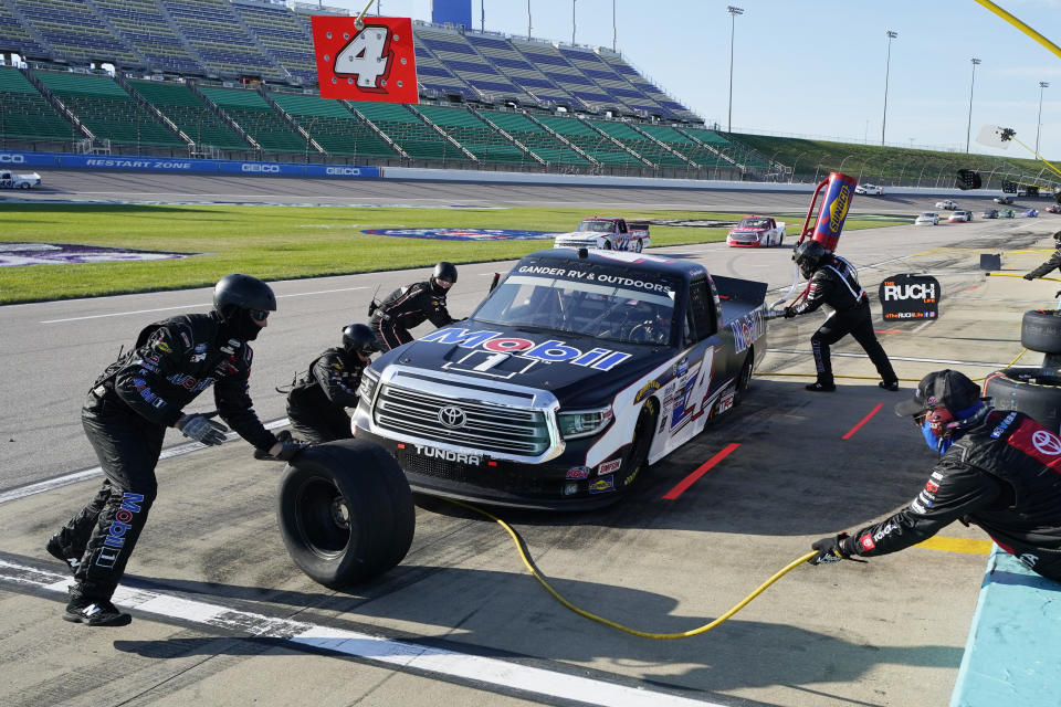 Raphael Lessard (4) makes a pit stop during a NASCAR Truck Series auto race at Kansas Speedway in Kansas City, Kan., Friday, July 24, 2020. (AP Photo/Charlie Riedel)