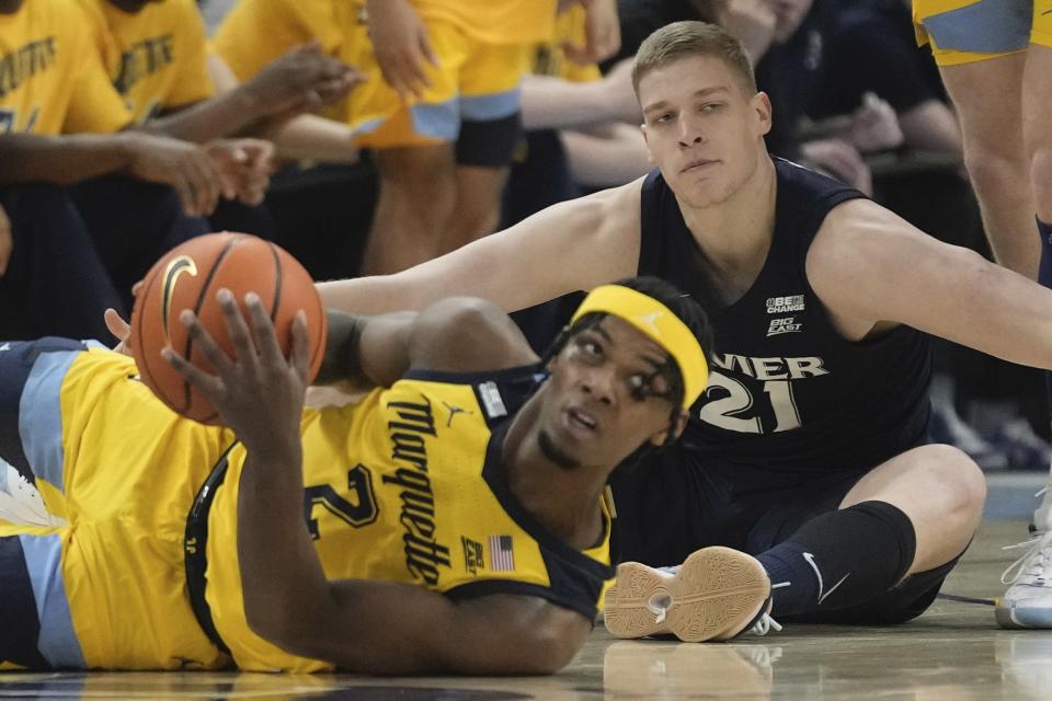 Marquette's Chase Ross looks to pass in front of Xavier's Sasa Ciani during the first half of an NCAA college basketball game Sunday, Feb. 25, 2024, in Milwaukee. (AP Photo/Morry Gash)