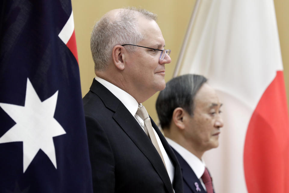 Australian Prime Minister Scott Morrison, left, with his Japanese counterpart Yoshihide Suga reviews an honor guard during a ceremony ahead of a meeting at Suga's official residence in Tokyo Tuesday, Nov. 17, 2020. Morrison is in Japan to hold talks with his Japanese counterpart, Yoshihide Suga, to bolster defense ties between the two U.S. allies to counter China’s growing assertiveness in the Asia-Pacific region. (Kiyoshi Ota/Pool Photo via AP)